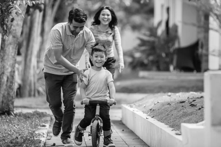 Mom & dad teaching child how to ride bike